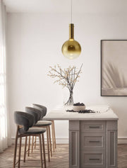 Nostos pendant light Ø 25cm 3000K above a modern dining table with stylish chairs and a decorative vase.