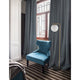 Nova Luce Alvarez floor lamp with golden frame and white globe shade, marble base, next to blue armchair