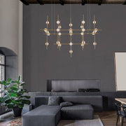 Atomo LED suspension 106 cm or dans un salon moderne avec un design élégant et une lumière d’ambiance.