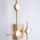 Atomo LED Wandleuchte Gold Acryl an Wand mit modernem Design und warmweißem Licht.
