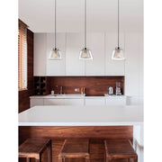 Boccale Glas-Hängeleuchte Klar, Chrom über einem modernen Küchentisch in einer eleganten Holzverkleidung.