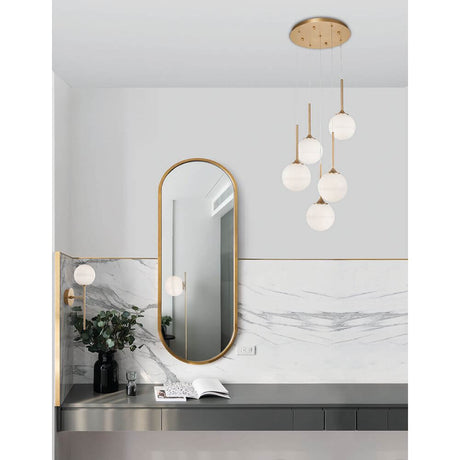 Cantona glass wall light brass, white in a modern room with mirror and stylish elements.