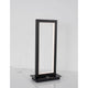 Cornice LED Tischlampe Schwarz auf einem Tisch, modernes Design mit eleganter Beleuchtung.