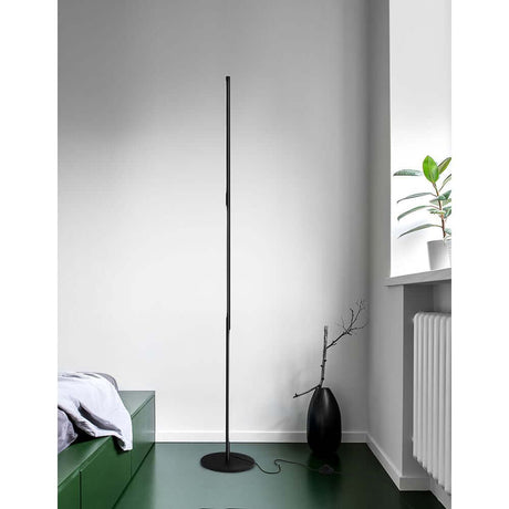 Handy LED floor lamp 171 cm black in a modern living space with plants and a green area