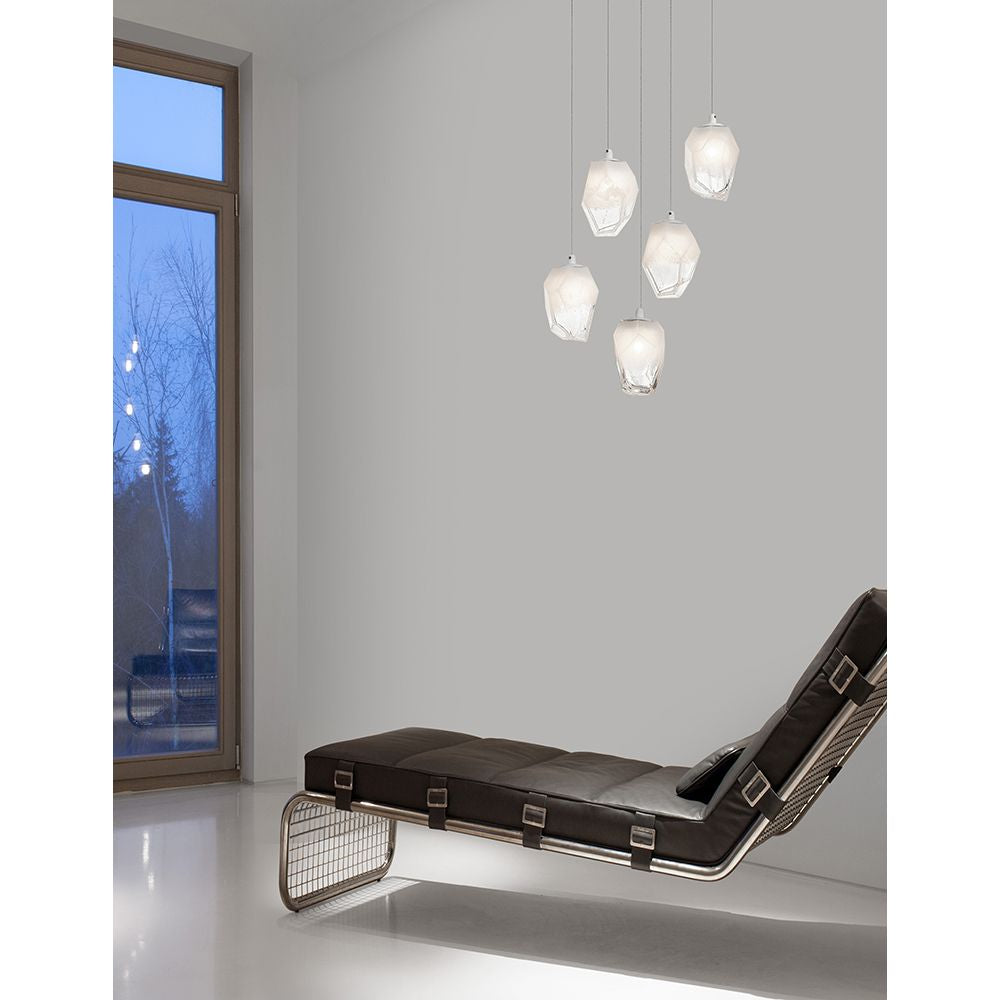 Moderne Ice Hängeleuchte mit 5 hängenden Leuchten in Verlaufend Weiß über einem eleganten Lounge-Sessel.