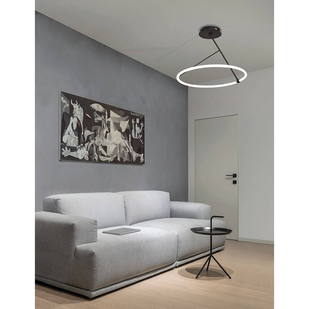 Helle Wohnlandschaft mit Janus LED Deckenleuchte Schwarz über einer grauen Couch.
