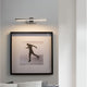 Nova Luce LED wall light Marnell silver, modern bathroom light mounted above picture frames on a white wall