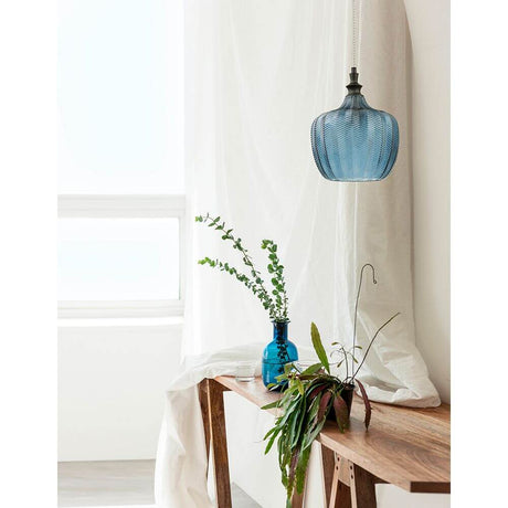 Loni glass pendant lamp Gradient Colored in a modern living space with plants and a decorative table.