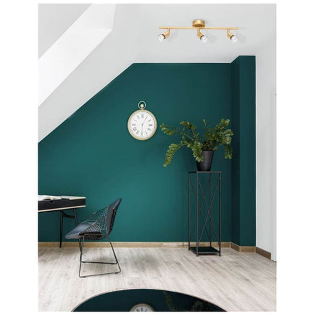 Lup 3-light bar spotlight made of metal on a stylish green wall with plants and a clock.