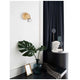 Lup Spot Wandlampe Metall an einer Wand mit stilvollem Dekor und Pflanzenarrangement.