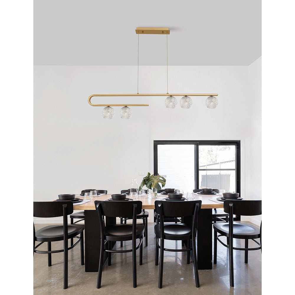 Moderne Mirano Hängeleuchte mit 5-gläsernen Kugeln in Gold über einem eleganten Esstisch.