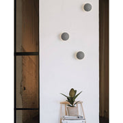 Netune LED Wandleuchte Ø 11cm an einer Wand, modernes Design in Grau und Weiß, ideal für verschiedene Räume.