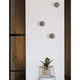 Netune LED Wandleuchte Ø 11cm an einer Wand, modernes Design in Grau und Weiß, ideal für verschiedene Räume.