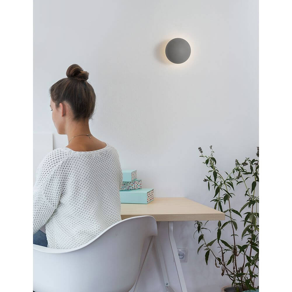 Netune LED Wandleuchte Ø 11cm an einer Wand über einem Schreibtisch, modernes Design im Esszimmer.