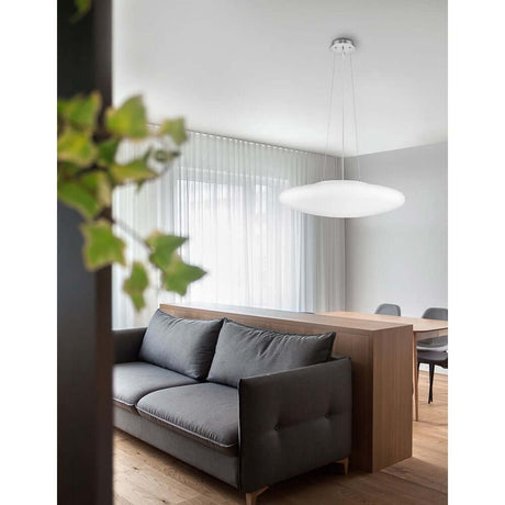 Suspension en verre Pressione Ø 60 cm blanche au-dessus d’un salon moderne dans une pièce élégante.