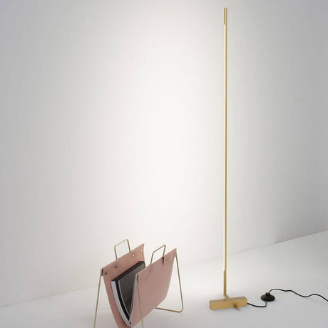 Lampadaire Raccio LED 140 cm Or à côté d’un porte-journaux dans un espace de vie moderne
