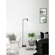 Nova Luce Sicily LED adjustable floor lamp in black with curved arm in a modern bedroom