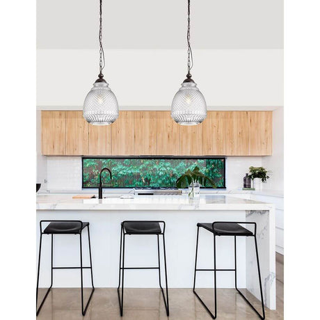 Toulon Glas-Pendellampe Metall über einer modernen Küche mit stylischen Barhockern.