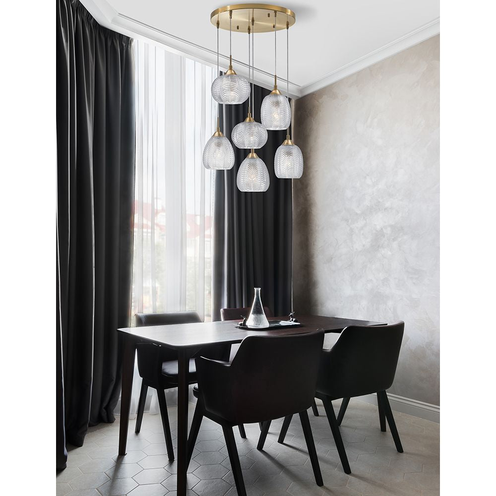 Vario Glas Hängeleuchte 6-flg. in Gold und Klar über einem modernen Esstisch mit schwarzen Stühlen.