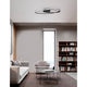 Viareggio LED Deckenlampe Geschwungen über modernem Wohnzimmer mit Sofa, Sessel und Bücherregal, minimalistisches Aluminium-Acryl-Design
