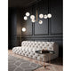 Moderne Vitra Glas-Hängeleuchte 8-flg. über elegantem Sofa in stilvollem Wohnzimmer mit dunkler Wand.