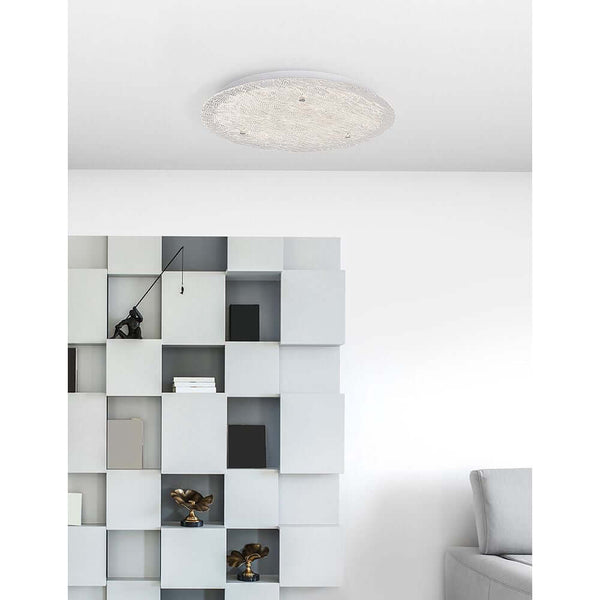 Wing LED ceiling lamp metal, glass on the ceiling in a modern living ambience with shelving system.