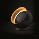 Oluce LED Tischleuchte Eva Schwarz, Goldfarben auf einem Tisch mit elegantem Design und einzigartiger Lichtwirkung.