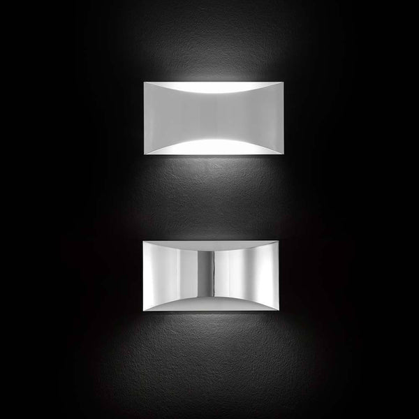 Oluce LED applique murale Kelly blanche au design moderne, deux luminaires élégants sur un mur sombre.
