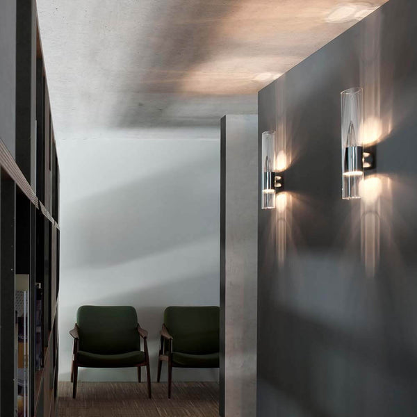 Oluce Glas Wandlampe Line Chrom an grauer Wand in modernem Flur, elegantes Design mit Lichtakzenten