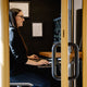 Frau in einem modernen Arbeitsraum, die am Computer sitzt und Pläne überprüft.