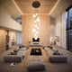 Modernes Wohnzimmer mit Holzdecke, hellen Lampen und stylischem Sofa-Arrangement.
