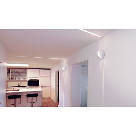Applique murale effet Orio LED 70 lm IP64 blanche dans un intérieur élégant avec une lumière blanc chaud.