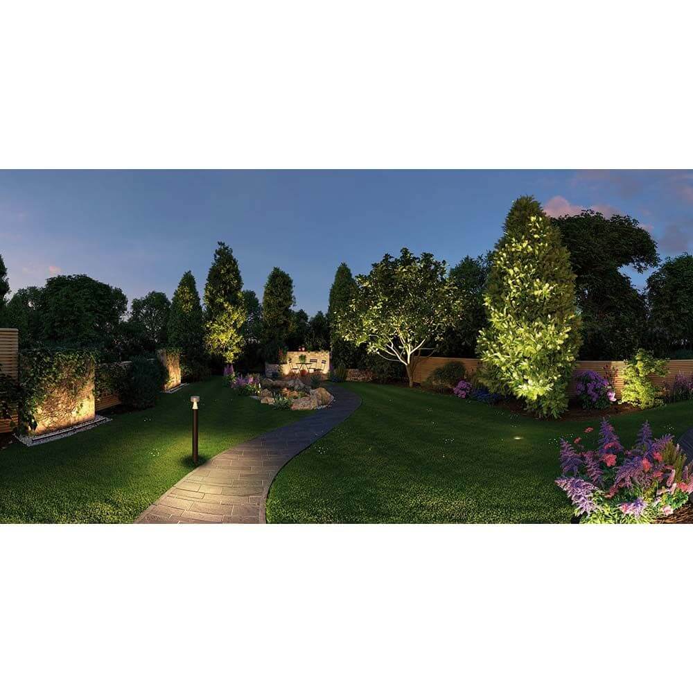 Beleuchteter Gartenweg mit verschiedenen Pflanzen und Bäumen bei Dämmerung, ideal für Plug & Shine Controller.