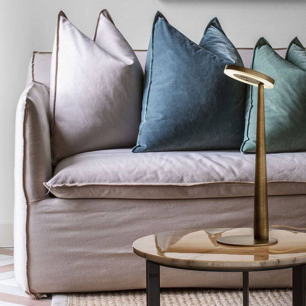 Panzeri Bella LED-Tischlampe Touchschalter auf einem Tisch neben einem Sofa mit dekorativen Kissen.