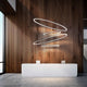Panzeri Brooklyn LED-Ring Pendelleuchte in modernem Empfangsbereich mit Holzwand.