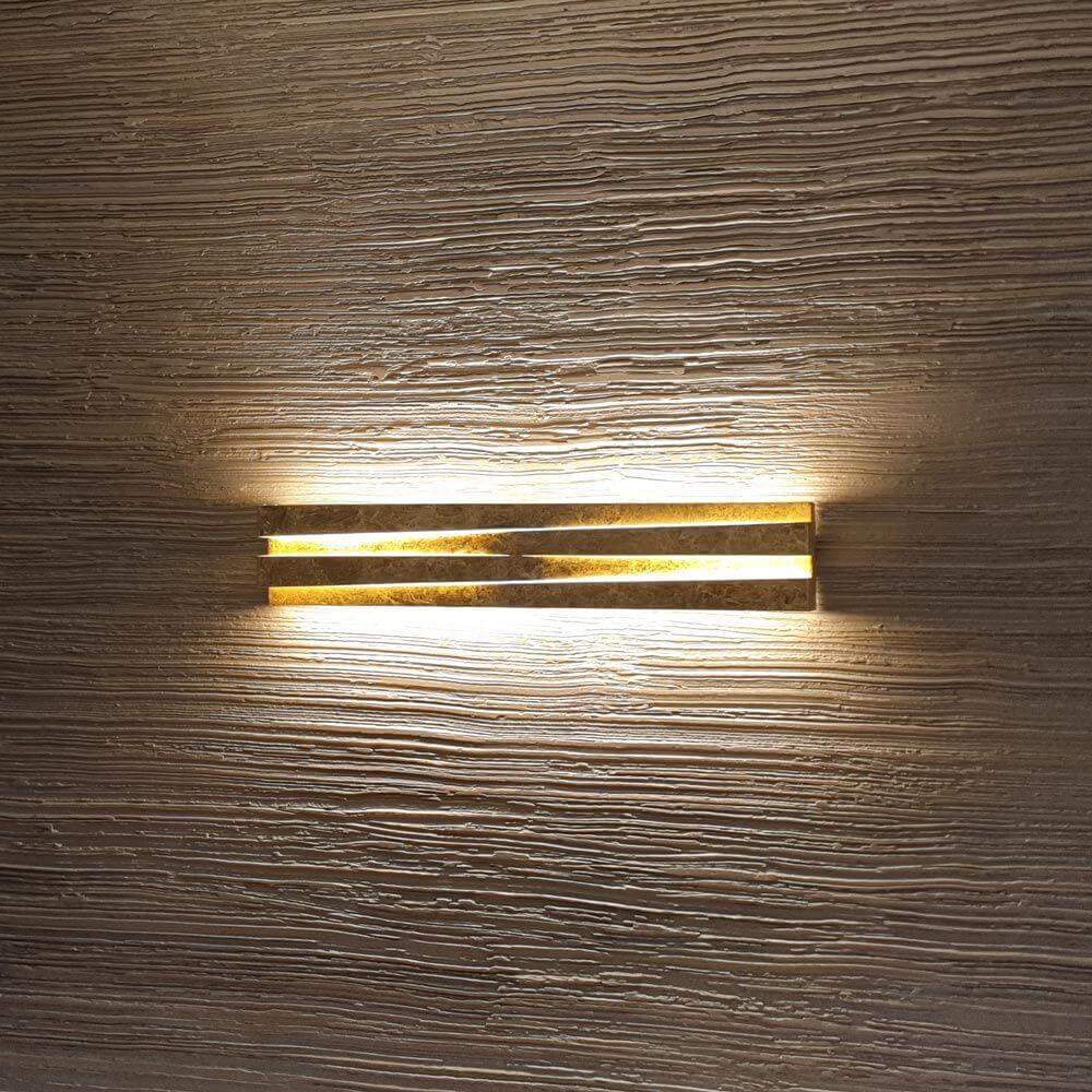 Panzeri Cross LED Wandlampe indirekt und direkt an strukturierter Wand, mit elegantem Licht- und Schattenspiel.