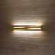 Panzeri Cross LED Wandlampe indirekt und direkt an strukturierter Wand, mit elegantem Licht- und Schattenspiel.
