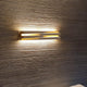 Panzeri Cross LED Wandlampe indirekt und direkt an einer strukturierten Wand mit warmem Licht.