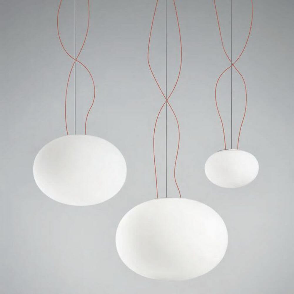 Panzeri Gilbert Glas Pendelleuchte in modernem Design, mit drei hängenden, weißen Glaskugeln und roten Kabeln.