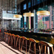 Panzeri Golden Ring LED-Pendelleuchte Dimmbar über einer modernen Bar in einem stilvollen Café.