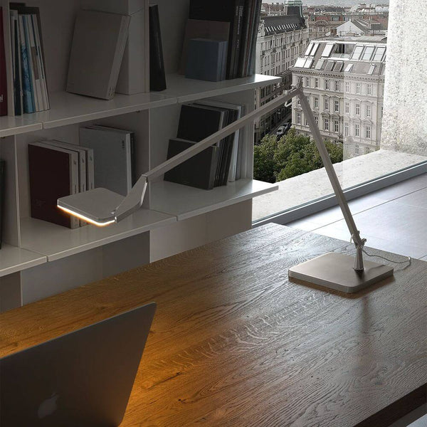 Panzeri Jackie LED-verstelbare tafellamp met touchdimmer op een modern bureau.