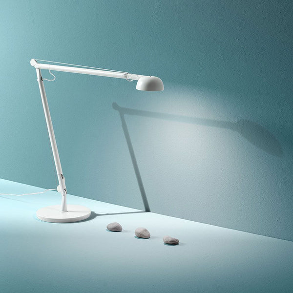 Lampe de bureau Panzeri Opuntia LED à intensité variable CCT sur fond bleu, réglable et moderne.