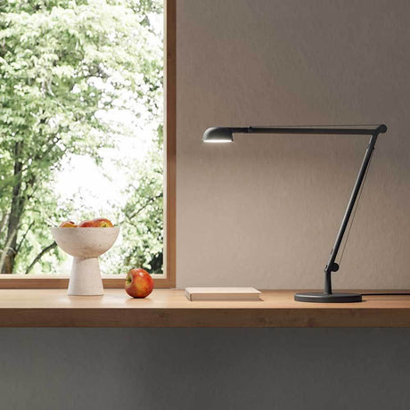 Panzeri Opuntia LED-Schreibtischlampe CCT-Dimmbar auf einem Tisch mit Äpfeln und natürlichem Licht.