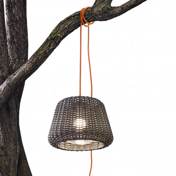 Panzeri Ralph Rattan Außen Pendelleuchte XXL mit handgeflochtenem Lampenschirm, aufgehängt an einem Baum.