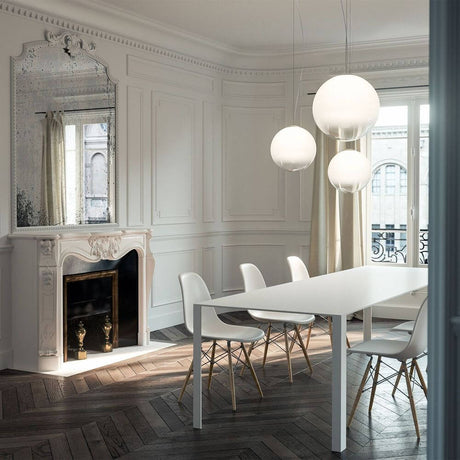 Panzeri Smoke blown glass pendant light in a modern dining area with a white table and stylish chairs.