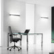 Panzeri Toy LED Wandleuchte Up&Down 60cm in modernem Büro mit Glastisch und Bürostuhl.