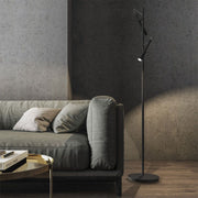 Panzeri Tubino LED floor lamp with twin head next to a sofa in a modern living room.