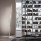 Panzeri Viisi LED-Stehleuchte für indirektes Licht in einem modernen Wohnraum mit Bücherregal.
