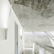 Panzeri Ypsilon LED Wandlampe indirekt in modernem Flur mit Betonwand und minimalistischer Architektur.