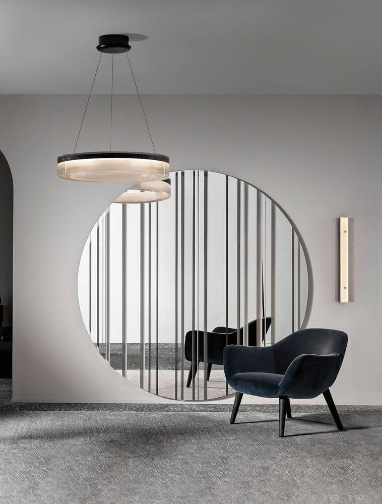 Moderne Pauline LED Pendelleuchte in Schwarz, schwebend über einem stilvollen Raum mit rundem Spiegel und Sessel.